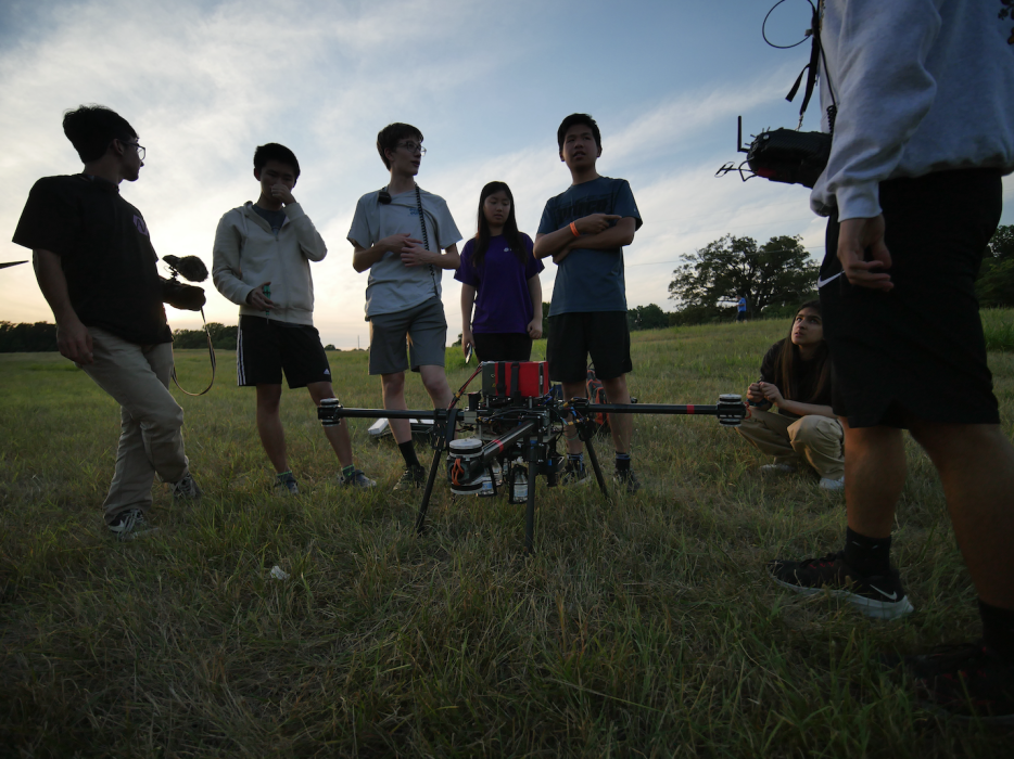 Our team testing our drone in a grass field