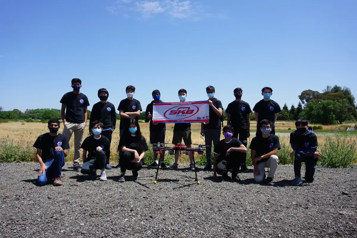 Our team posing with a banner from one of our sponsors, SKB Cases